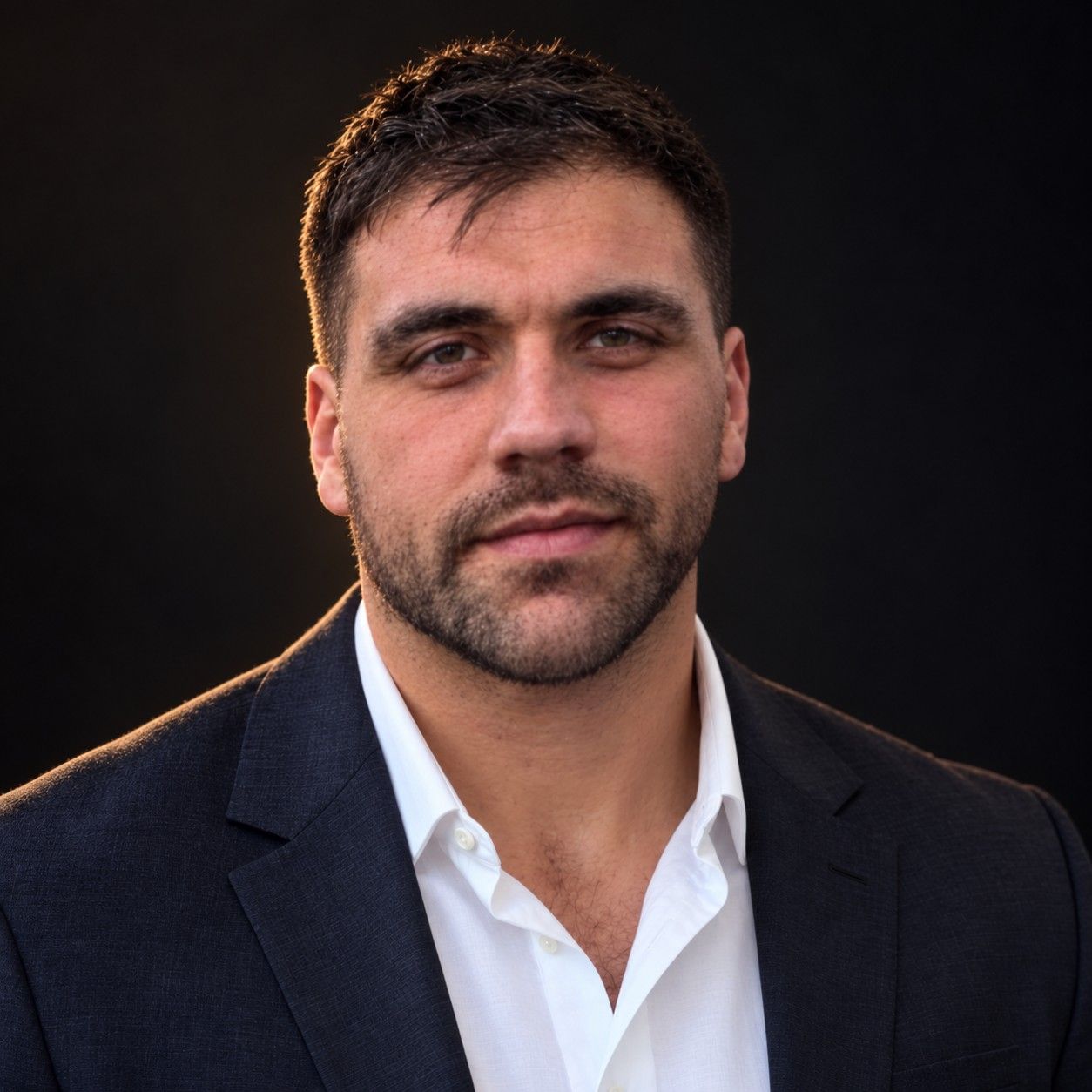 Paul Rammeloo, founder of Black Reach Media, in a navy suit jacket and white open-collar shirt.
